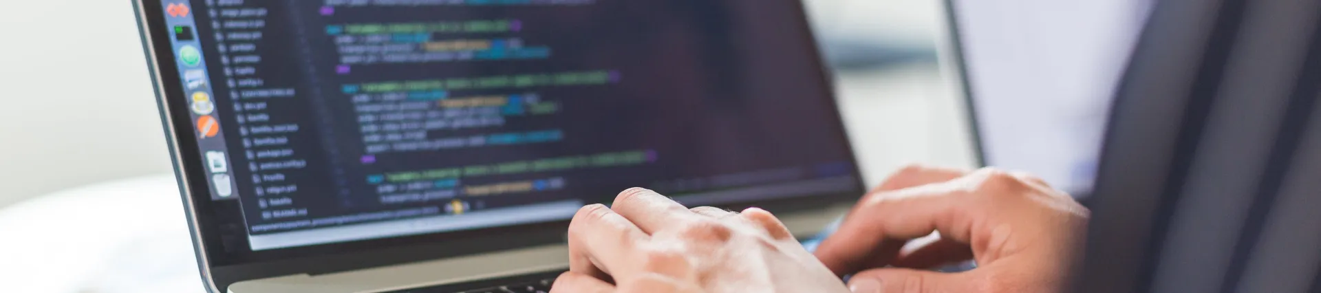 Software developer hard at work, coding on a laptop